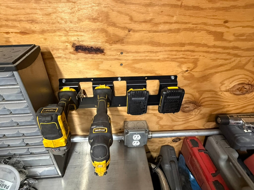 Keepfast rack on a shop wall holding DeWalt 20V drills and batteries