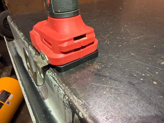 Milwaukee M18 drill on a Keepfast tool holder at the edge of a workbench